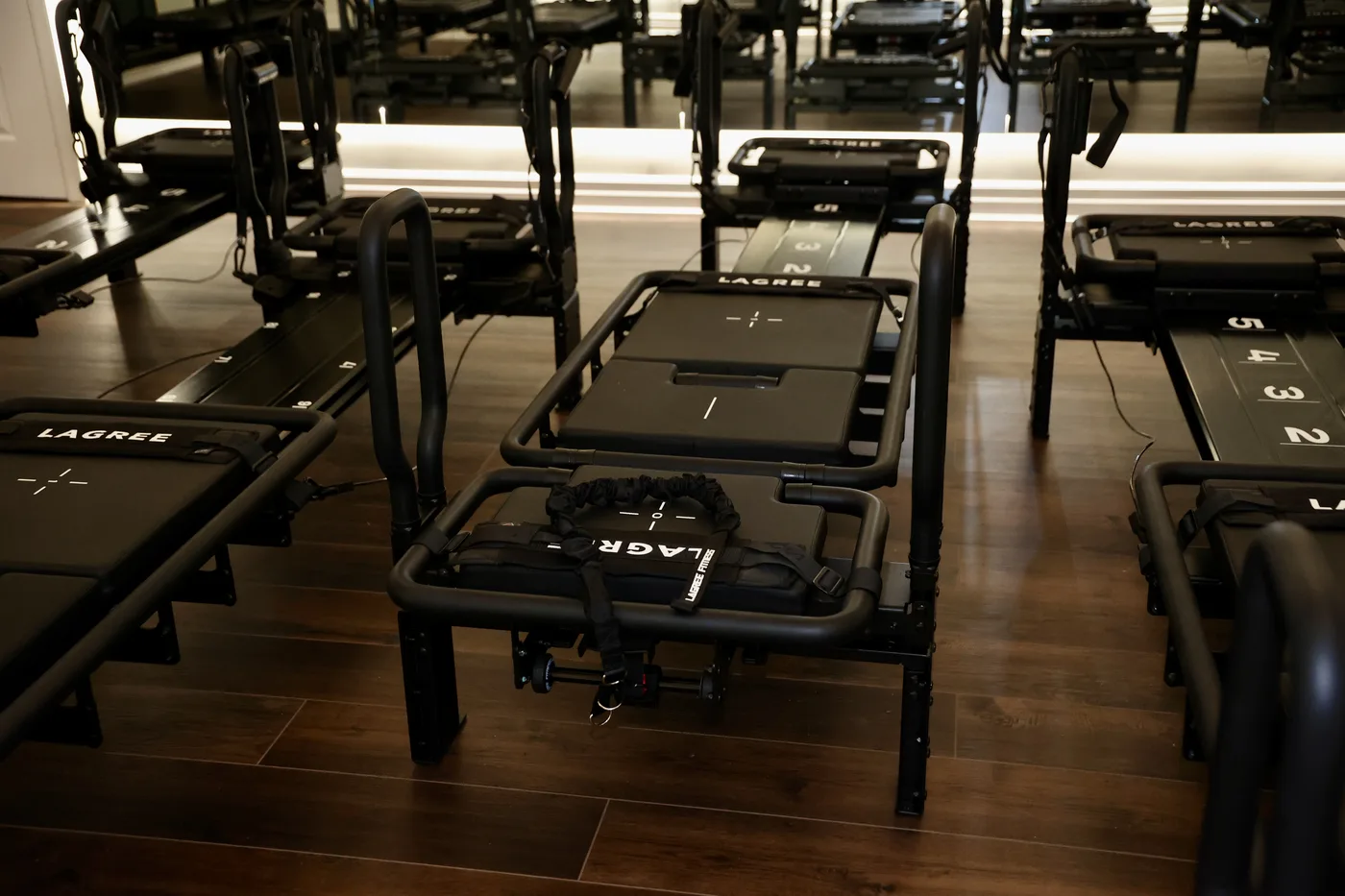 Rows of black Mini Pro machines on dark walnut floors in low light